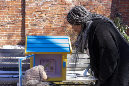 Michele Richardson and a young volunteer add books